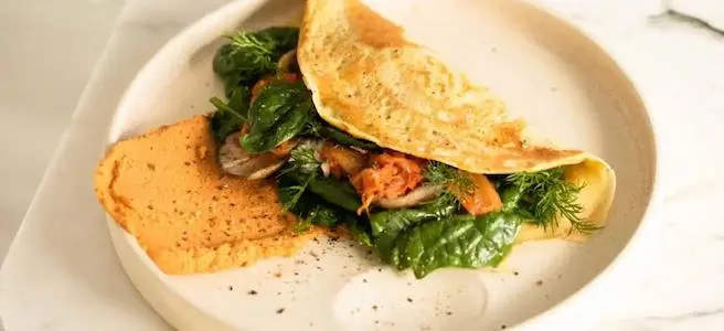 A golden-brown omelette folded with fresh vegetables